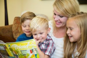 Mormoniäiti perheineen lukemassa kirkon lastenlehteä