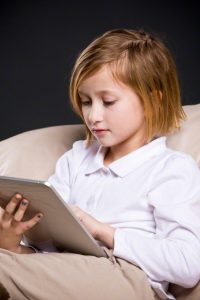 Pieni tyttö selaa internetiä tabletilla