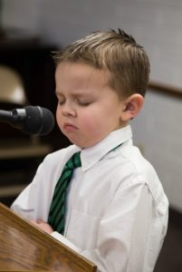 Pieni poika rukoilee kirkossa